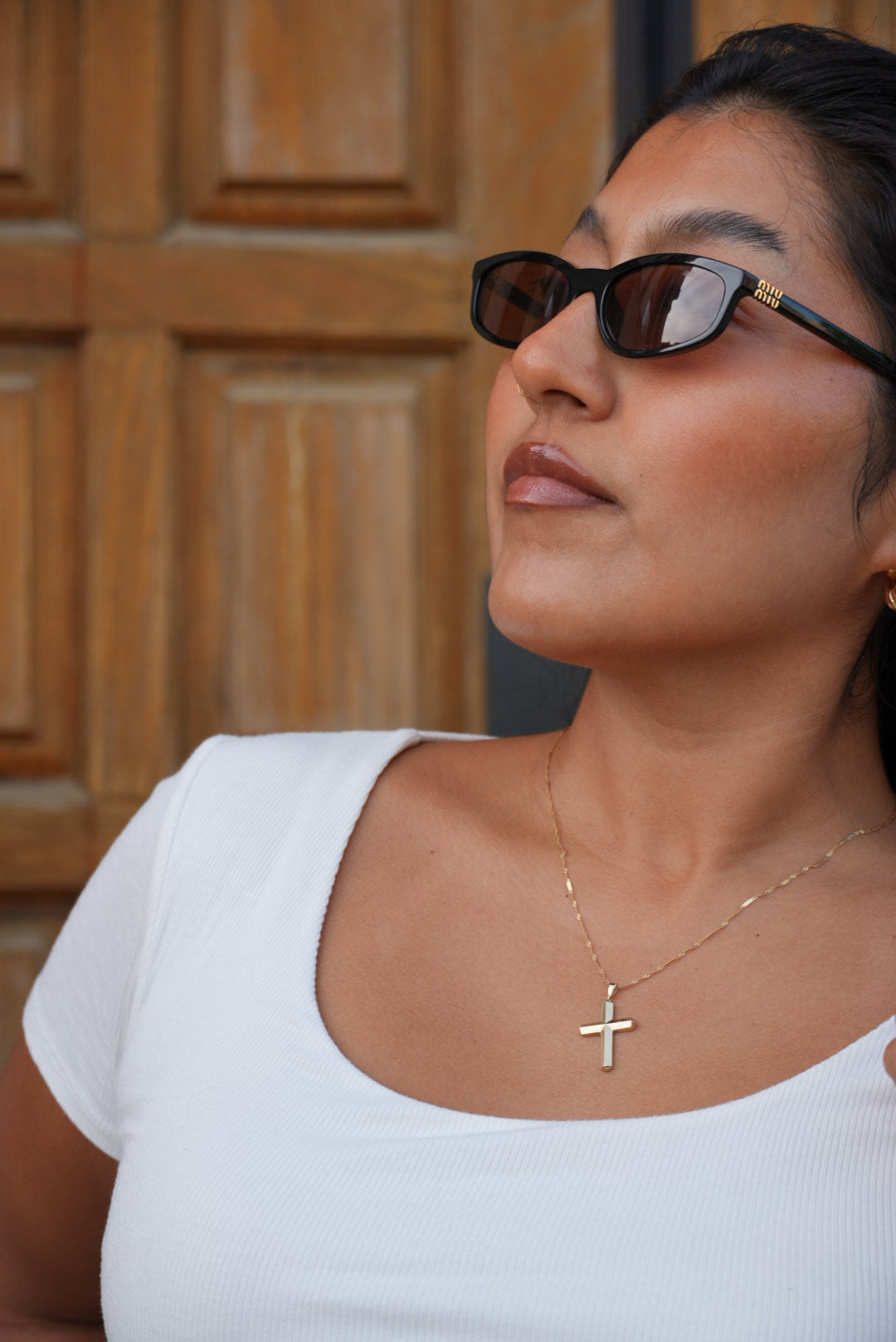 model wearing senoe gold cross pendant in 10k yellow gold