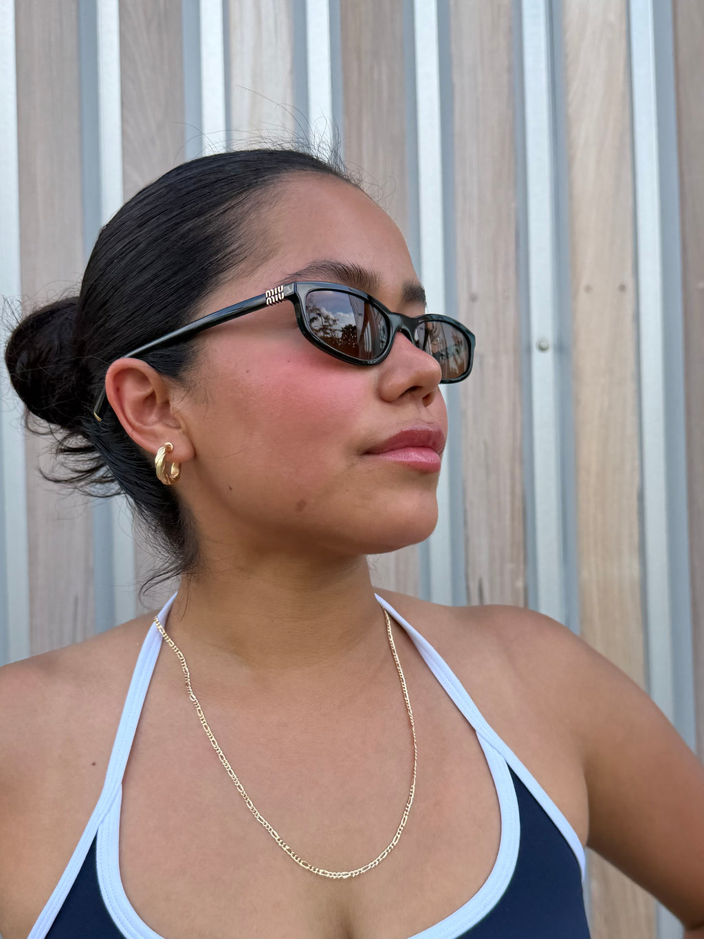 model wearing senoe twisted hoop earrings in 14k yellow gold 